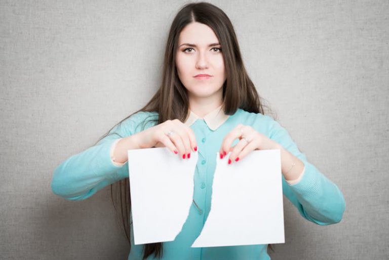 Eine Frau zerreißt ein Papier