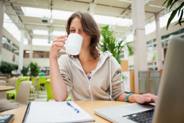 Eine Studentin sitzt im Cafe und macht eine Steuererklärung