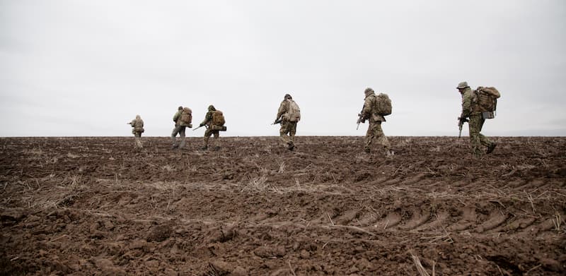 Mehrere Soldaten der Bundeswehr beim Marsch durch den Schlamm