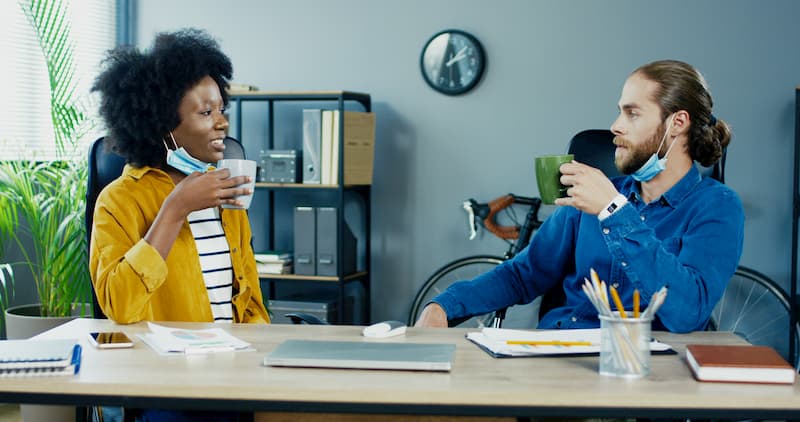 Zwei Mitarbeiter machen eine Kaffeepause - häuft es sich, kann es sich um Arbeitszeitbetrug handeln