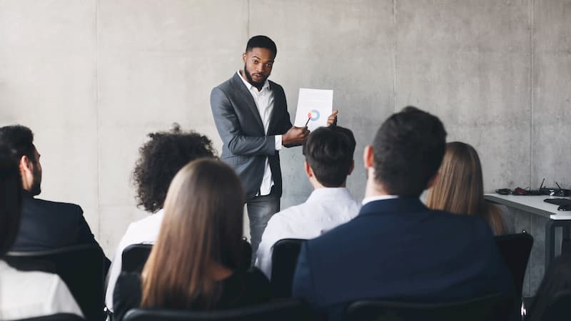 Ein Manager erklärt Mitarbeitern die betriebliche Altersvorsorge