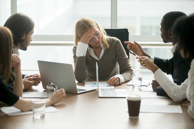 Eine Geschäftsfrau ist im Meeting und leidet unter Burnout
