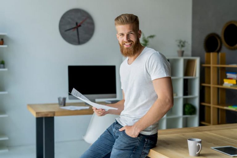 Ein junger Mann hält ein einfaches Arbeitszeugnis in der Hand