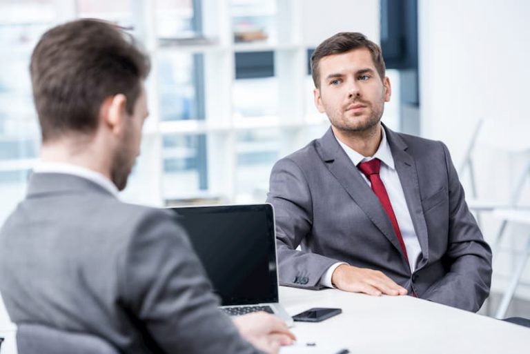 Ein Mann verhandelt im Gespräch mit dem Chef sein Einstiegsgehalt