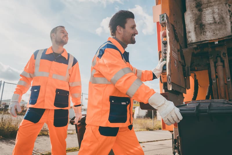 Arbeiter der Müllabfuhr tragen Arbeitskleidung