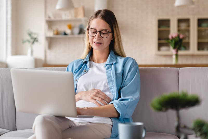 Eine Schwangere informiert sich am Laptop über das Mutterschutzgesetz