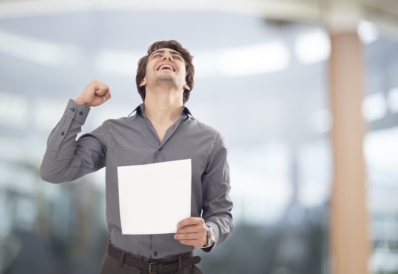 Ein junger Mann jubelt er konnte die Ausbildung verkürzen