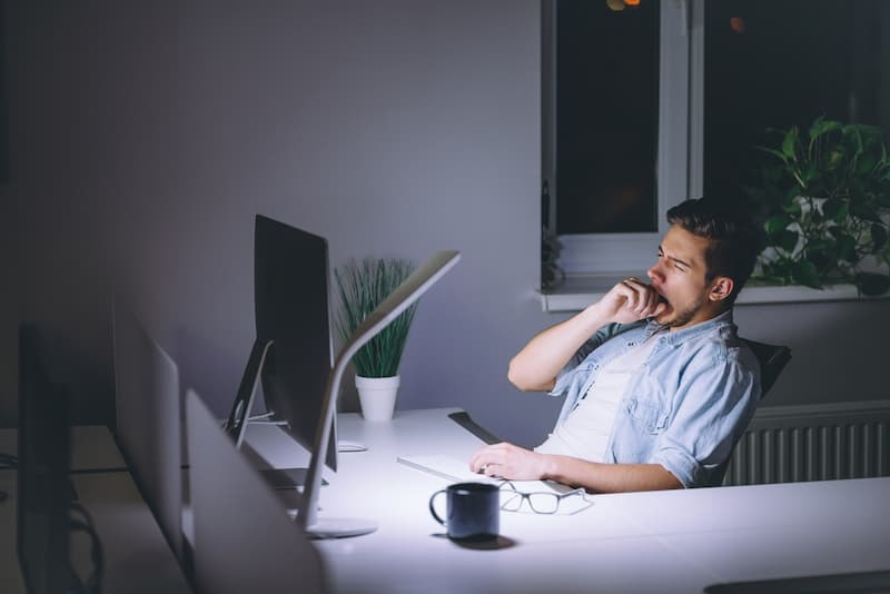 Ein Mann arbeitet abends im Büro, er erhält einen Überstundenausgleich