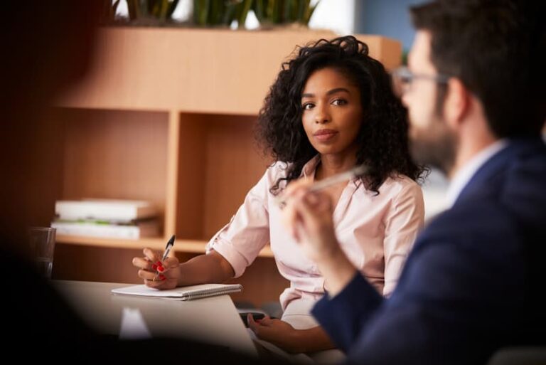 Eine Frau schreibt im Meeting ein Protokoll