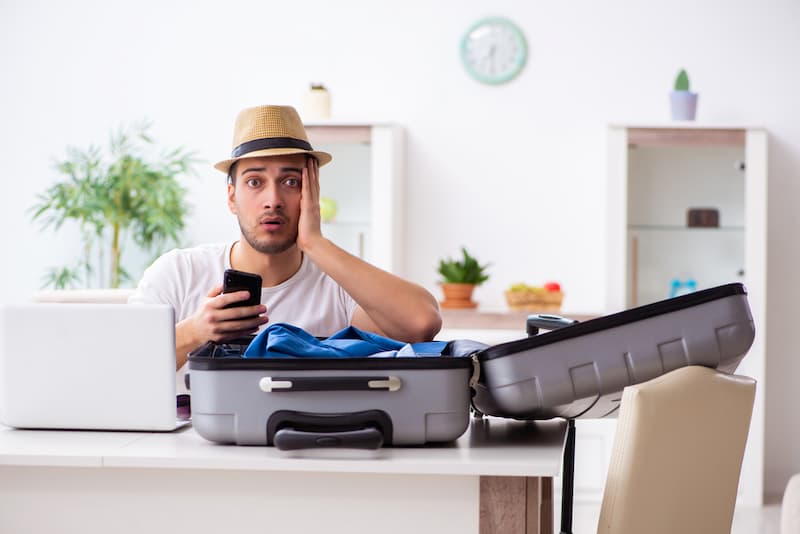 Ein Mann packt seinen Koffer und erhält einen Anruf, darf ein Unternehmen den Urlaub streichen?