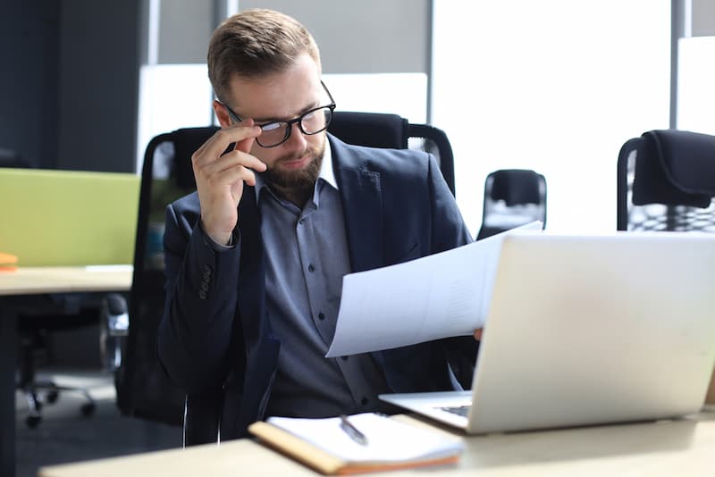 Ein Mann durchblickt den Arbeitsvertrag, er möchte den Arbeitgeber abmahnen