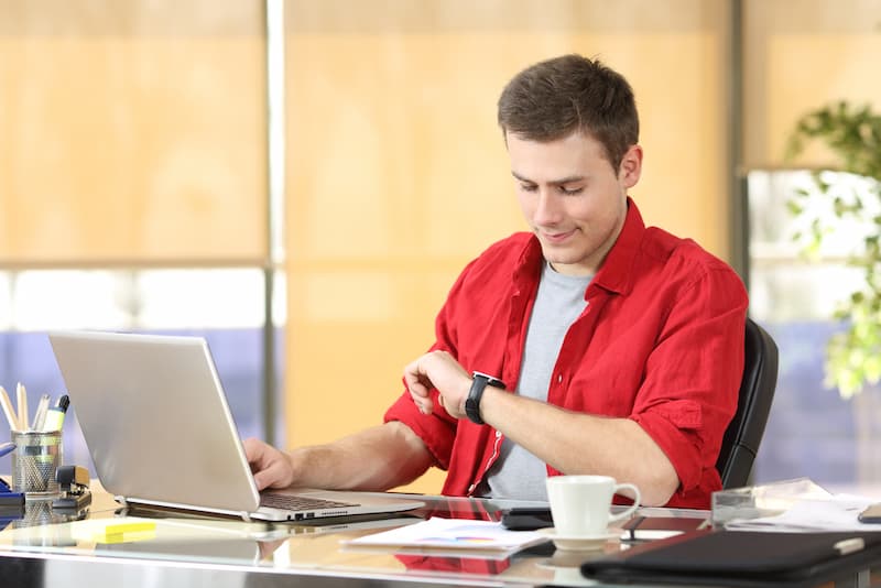 Ein Mann schaut auf die Uhr, er arbeitet in der Kernarbeitszeit