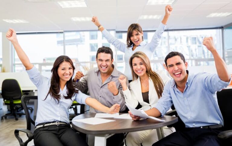 Eine Gruppe im Büro freut sich und zeigt dadurch Enthusiasmus