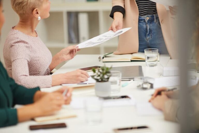 Eine Frau verteilt ein Papier zum Thema Handout gestalten