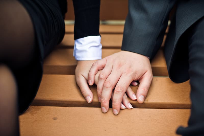 Zwei Menschen halten die Hände, sie haben eine Beziehung am Arbeitsplatz