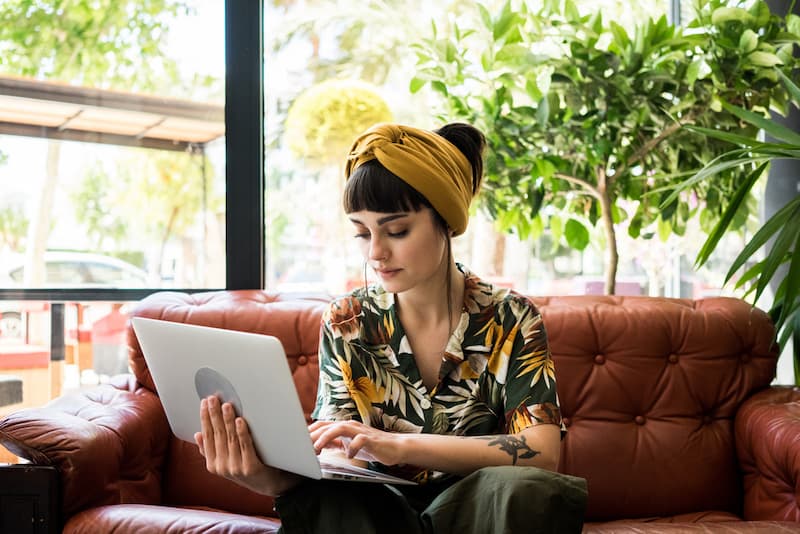 Eine Frau sitzt in einem Cafe und macht Remote Work