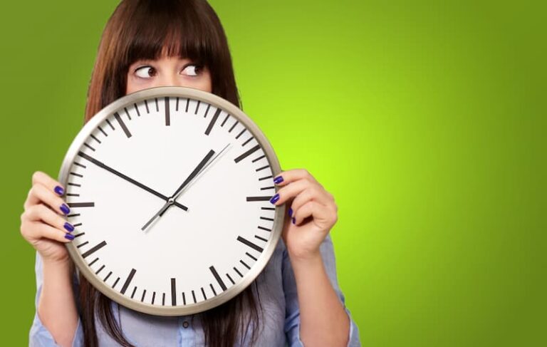 Eine Frau hält eine Uhr, was gibt es für flexible Arbeitszeitmodelle?