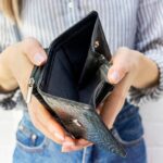 Eine Frau hält ein leeres Portemonnaie, wann ist eine Lohnkürzung erlaubt?