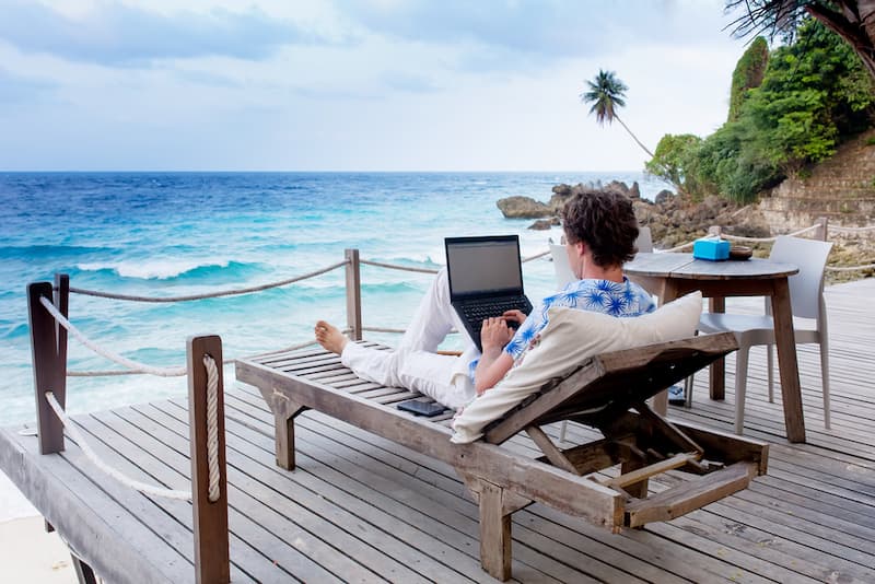 Ein Mann arbeitet am Strand als Freelancer