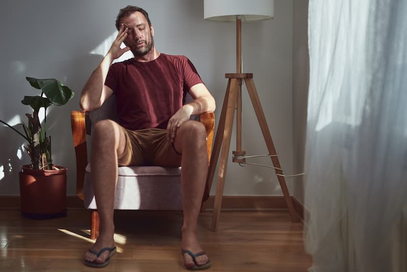 Psychisch krank nach Kündigung: Das kann Ihnen helfen 1 Ein Mann sitzt Zuhause, er ist psychisch krank nach der Kündigung