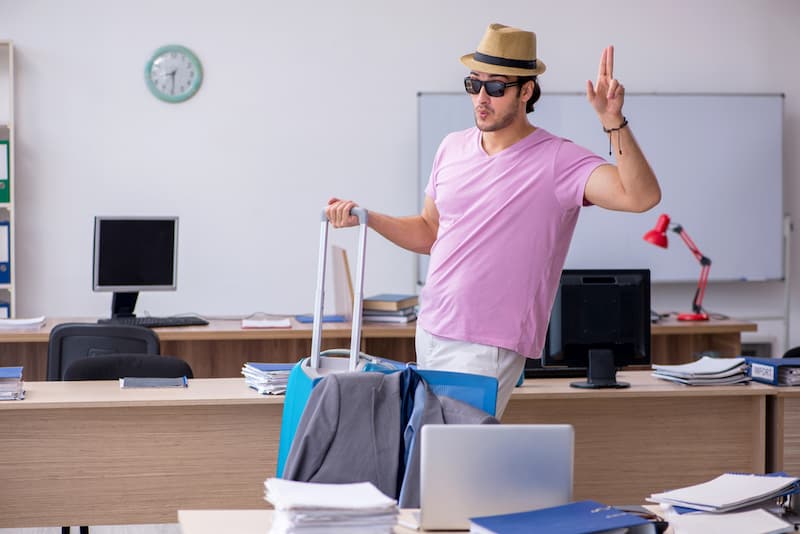 Ein Mann mit Koffer im Büro, was geschieht bei Selbstbeurlaubung?