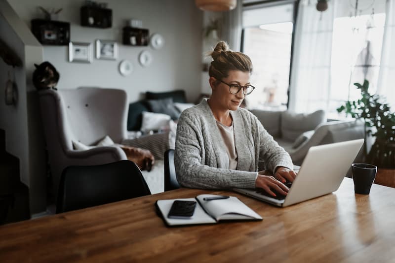 Eine Frau sitzt am Schreibtisch und macht Heimarbeit