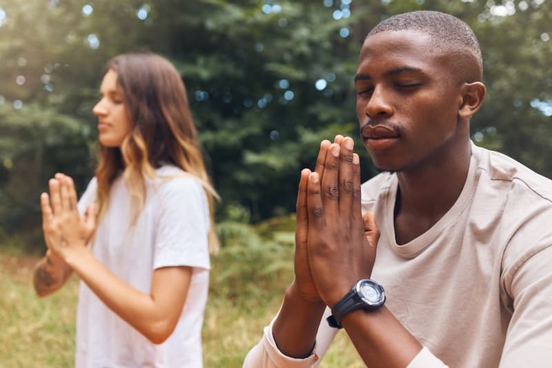 Zwei Menschen machen Übungen im Freien, wie steigert man die Stressresistenz im Job?