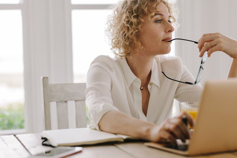 Eine Frau arbeitet am Laptop und denkt nach, lässt sich eine Kündigung zurückziehen?