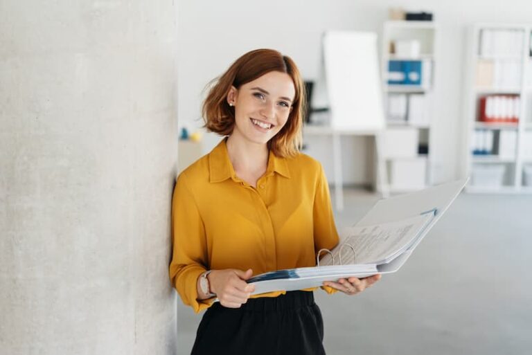 Eine junge Frau mit einem Ordner in der Hand, was gilt während der Probezeit in der Ausbildung?