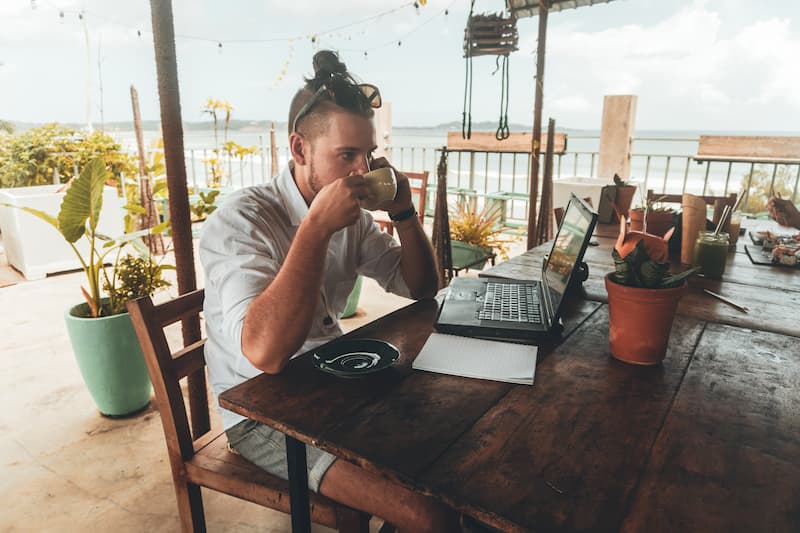 Ein Mann mit Laptop in einem Cafe, was sind digitale Nomaden?