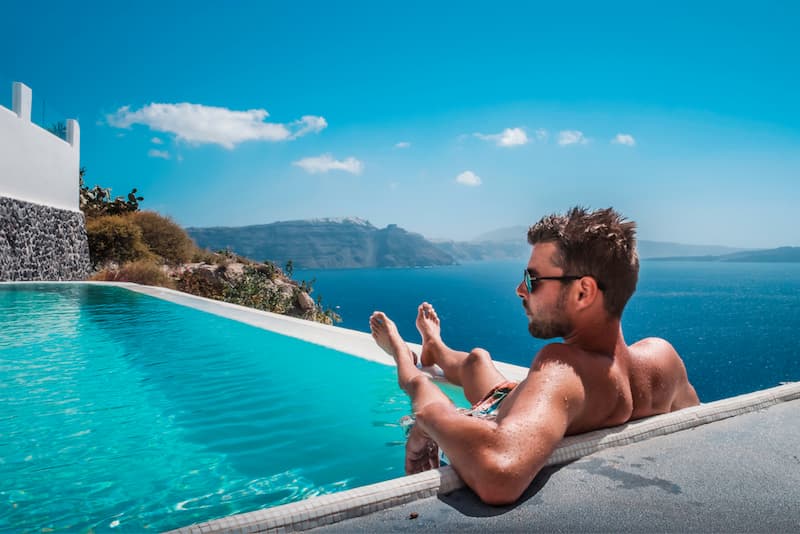 Ein Mann liegt an einem Pool, wie sollte man den Urlaub planen in 2024?