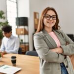 Eine Frau steht im Vordergrund im Büro, was ist Female Leadership?