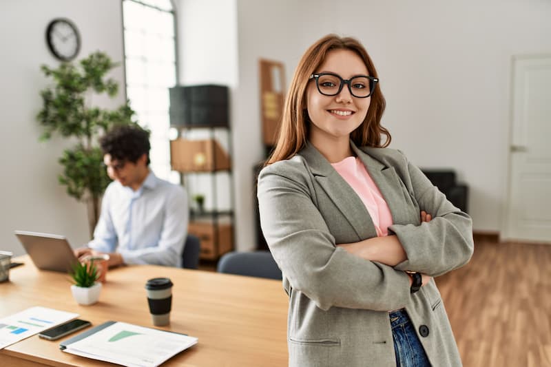 Eine Frau steht im Vordergrund im Büro, was ist Female Leadership?