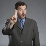 Ein Mann hält den Zeigefinger hoch, was ist Manterrupting?