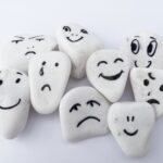Mehrere Steine mit aufgemalten Gesichtern, was ist emotionale Kompetenz im Beruf?