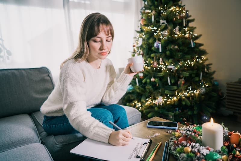 Eine Frau schreibt sich Neujahrsvorsätze auf