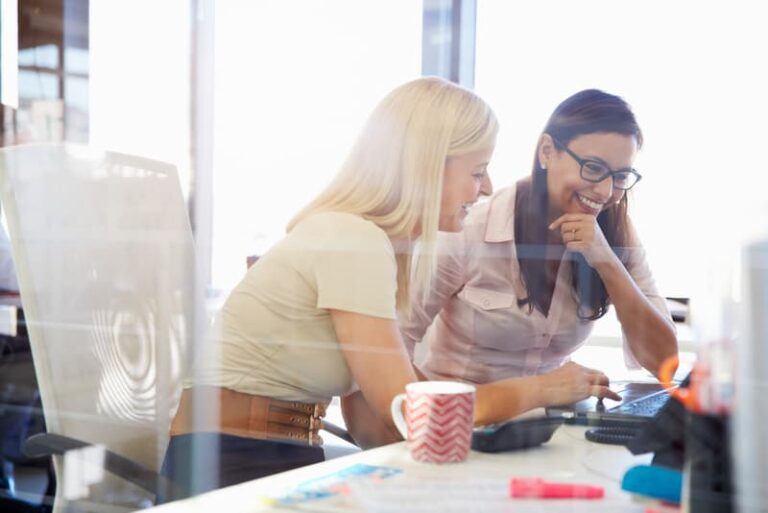 Zwei Frauen arbeiten miteinander, was ist ein Mentoring Programm?