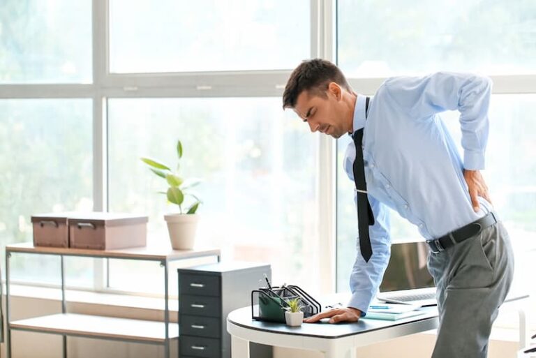 Ein Mann hat im Büro Rückenschmerzen