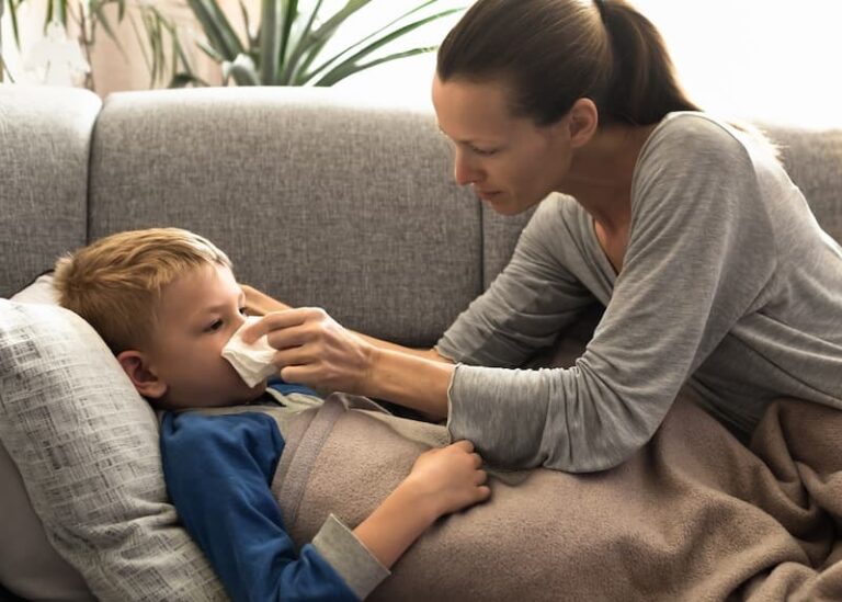 Eine Mutter kümmert sich um ihr krankes Kind, was ist Kinderkrankengeld?