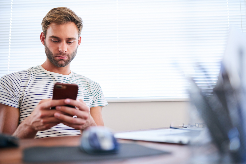 Von der Prokrastination zum Karriere-Boost: So schaffen Sie es 1 prokrastination mann am smartphone