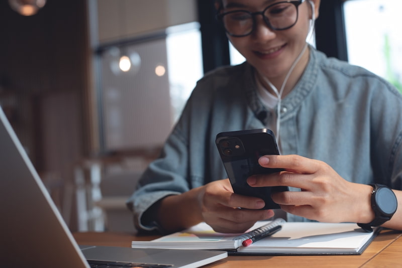 Was ist Microlearning? Ansatz, Beispiele und Vorteile 1 frau nutzt smartphone fuer microlearning