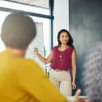 Eine Frau mir gutem Personal Branding hält einen Vortrag. Dafür nutzt sie ein Whiteboard. Sie erklärt "Was ist Personal Branding?"