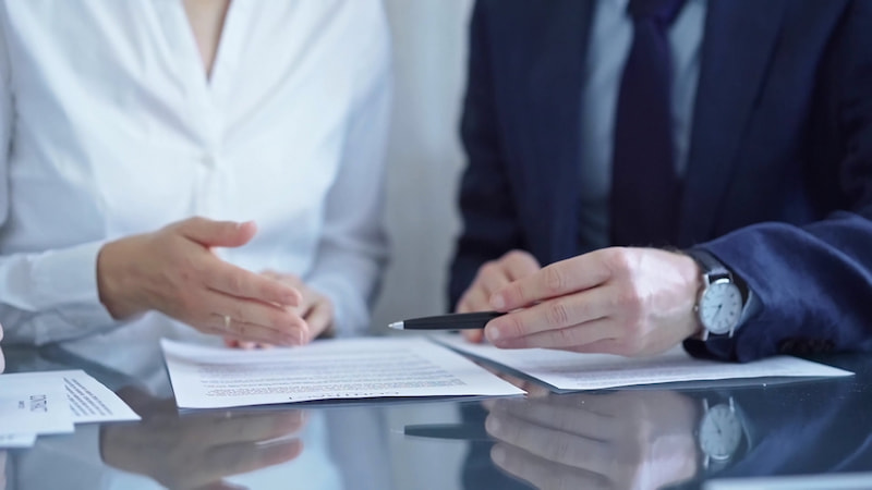 Chef geht Aenderungsvertrag mit Mitarbeiterin durch